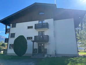 A two-story building with a white facade, multiple balconies, and a well-maintained lawn. - Cozy studio, pets welcome - 2 guests (Samoëns)