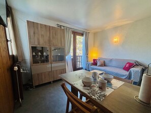 A compact living space with a dining table, a sofa, and a cabinet with glass doors. - Cozy studio, pets welcome - 2 guests (Samoëns)