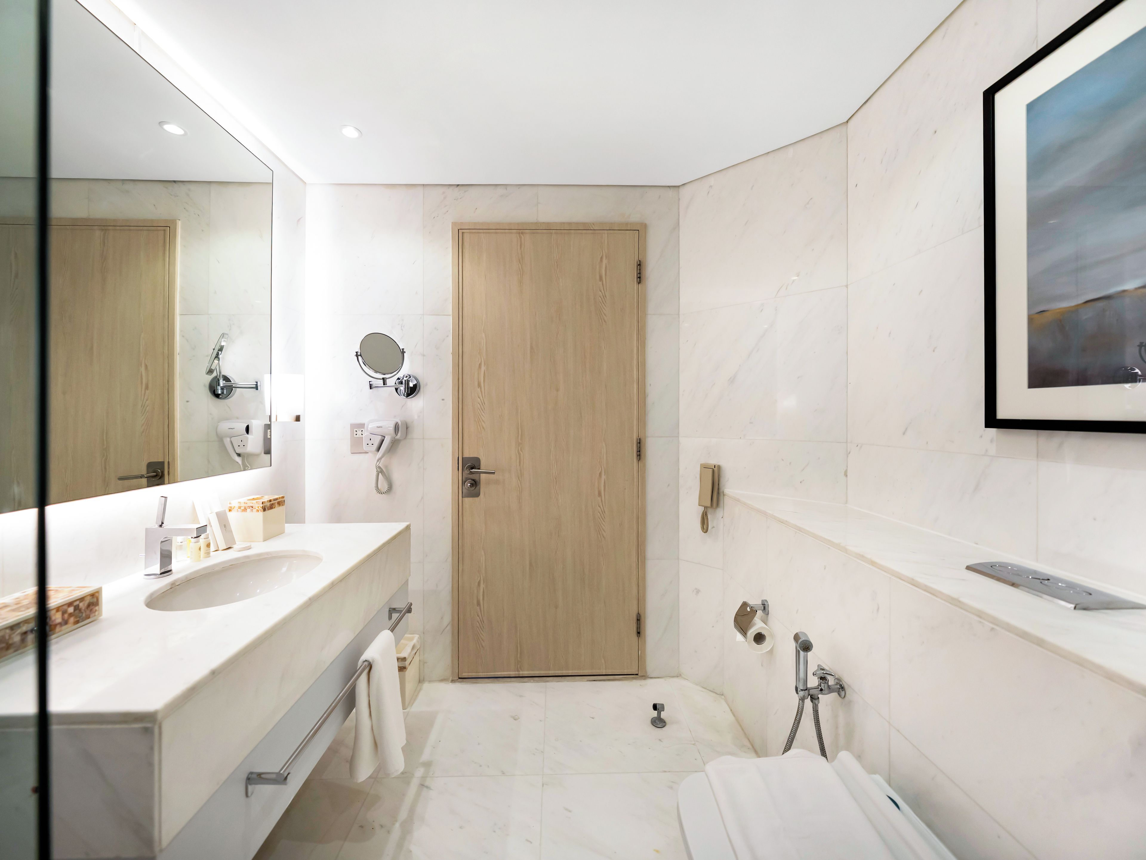 Ein modernes Badezimmer mit großem Spiegel, zwei Waschbecken, einer Dusche und einer Toilette.