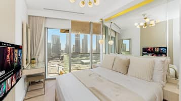 Ein modernes Hotelzimmer mit einem großen Bett, Blick auf die Stadt und einem Fernseher, der einen Film zeigt.
