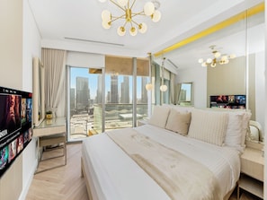 Ein modernes Hotelzimmer mit einem großen Bett, Blick auf die Stadt und einem Fernseher, der einen Film zeigt.