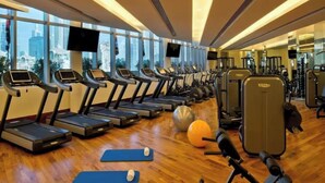 Un gimnasio con cintas de correr, pelotas de ejercicio y pesas.