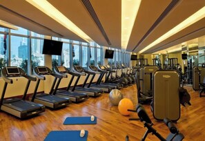 Ein Fitnessstudio mit Laufbändern, Gymbällen und Gewichten.