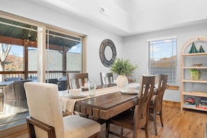 A dining area with a wooden table, chairs, and a potted plant. - Pond View Hot Tub 4 Ensuite Bedrooms Lazy River (Hollister)