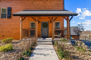 Une cabane en bois avec un porche, une porte ornée d’une guirlande et une plaque portant le numéro « 4 ».