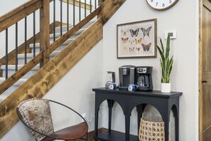 A staircase with wooden railings, a coffee station with a clock, and a framed butterfly artwork on the wall. - Pond View Hot Tub 4 Ensuite Bedrooms Lazy River (Hollister)