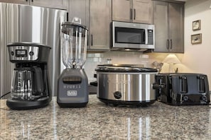 A kitchen with a coffee maker, blender, slow cooker, microwave, and toaster. - Pond View Hot Tub 4 Ensuite Bedrooms Lazy River (Hollister)