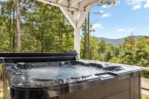 A hot tub with a view of a forest and mountains. - Woodland Dreams by Carolina Mornings | Hot Tub, Fire Pit, & Mtn Views Near AVL (Swannanoa)