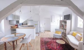 A modern living space with a kitchen, dining area, and seating area. - A CLASSIC FRENCH CHARACTER WITH A FRESH, CONTEMPORARY INTERIOR. (Paris)