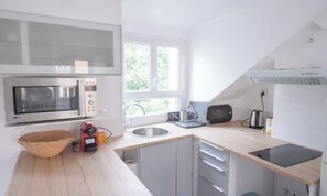 A modern kitchen with a microwave, toaster, and sink. - SPACIOUS RENOVATED STUDIO IN THE HEART OF PARIS (Paris)