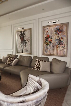 Ein modernes Wohnzimmer mit einer Eckcouch, einem Couchtisch und zwei gerahmten Kunstwerken an der Wand.