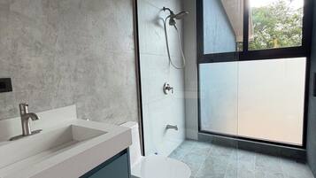 Ein modernes Badezimmer mit einem Doppelwaschbecken, Toilette und einer Duschkabine.