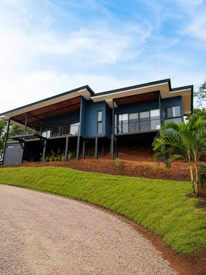 A modern two-story house with a flat roof, large windows, and a covered porch area. - Aurelia | Exclusive Mountain Villa near Monteverde (Abangares)