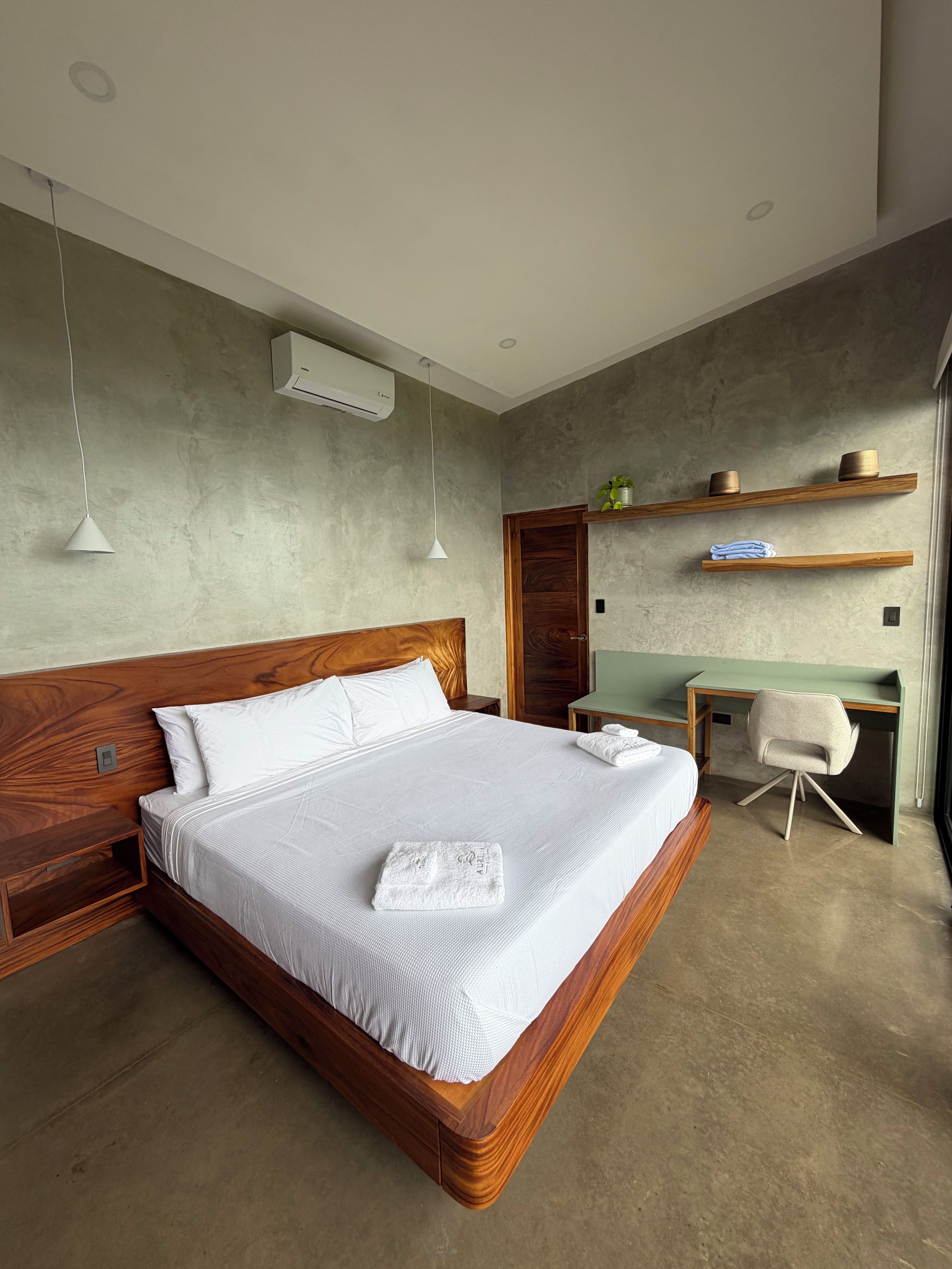 A modern bedroom with a wooden bed, a desk, and a chair.