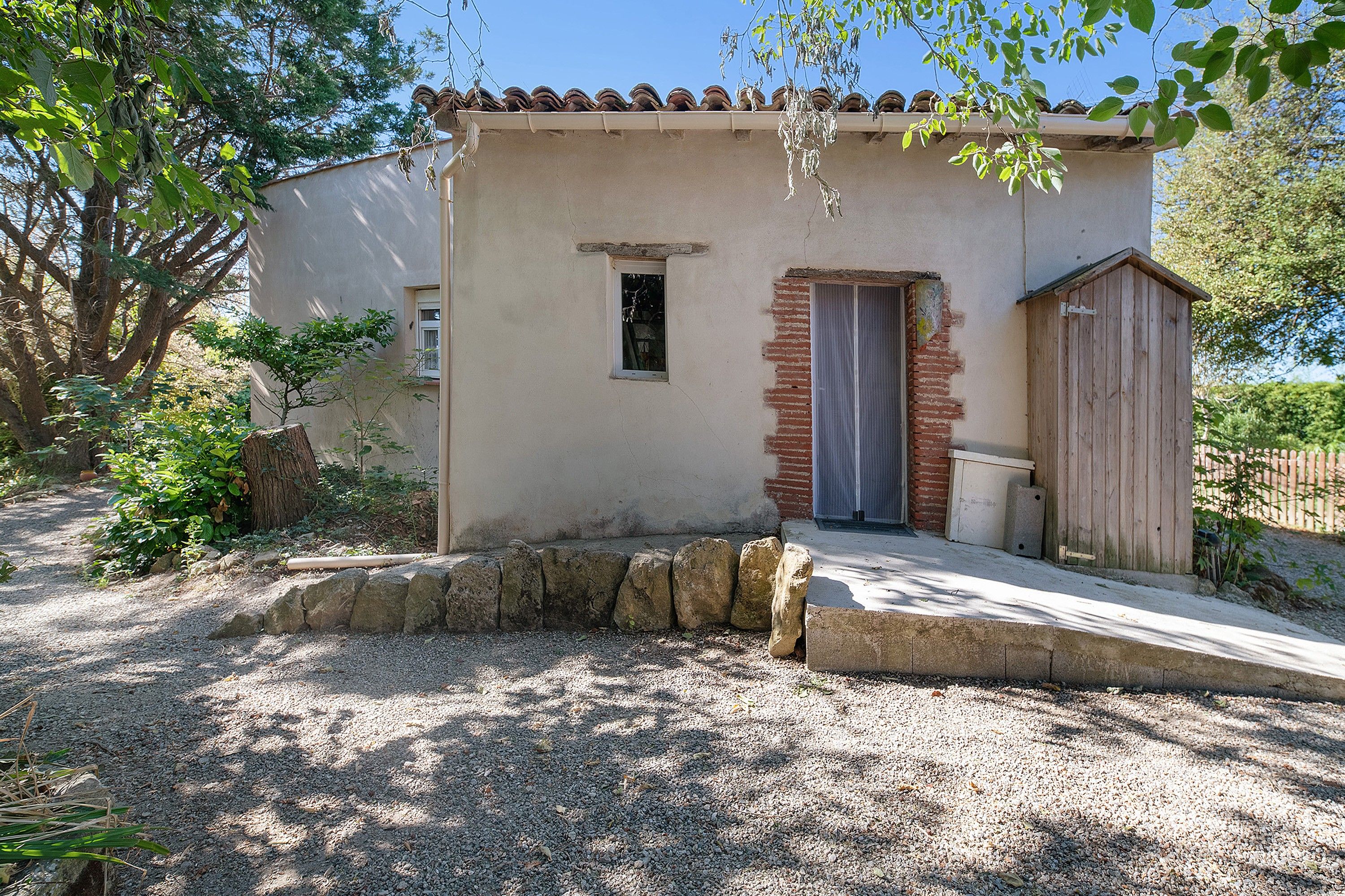 Un petit bâtiment avec un toit en tuiles, une porte et une fenêtre.