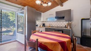 A kitchen with a dining area, a washing machine, and a large window.