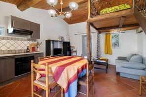 A compact living space with a kitchen, dining area, and a sofa. - Le Tournesol Gîte – Mountain View, Shared Pool & Wi-Fi (Salles-sur-l'Hers)