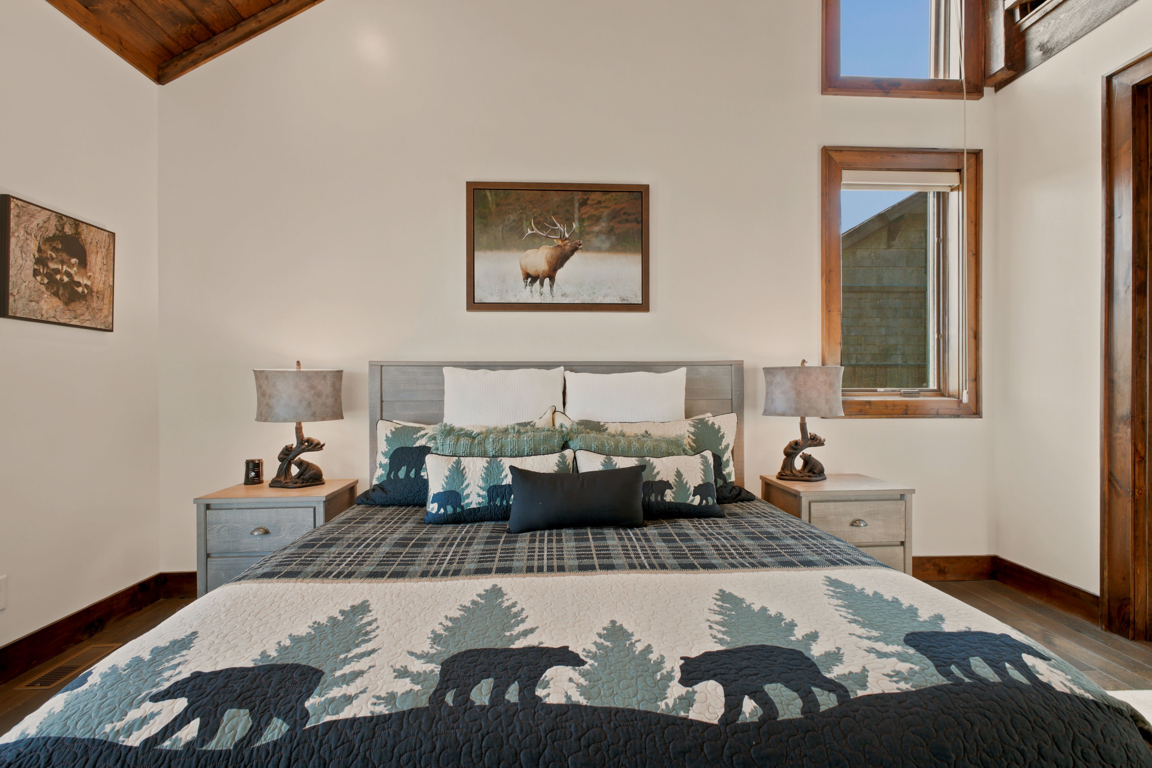 Ein Schlafzimmer mit einem großen Bett, zwei Nachttischen, einem Fenster und einem Bild an der Wand.