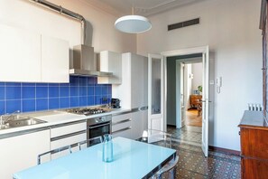 A modern kitchen with a central island, a built-in oven, and a blue-tiled backsplash. - Downtown Milan FamilySuite | 6 beds w/ workspace (Milano)