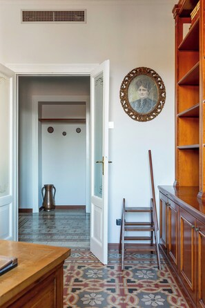 An open doorway leading to a room with a patterned floor, a metal kettle, and a wooden ladder. - Downtown Milan FamilySuite | 6 beds w/ workspace (Milano)