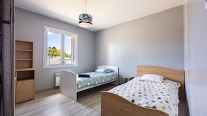 A bedroom with a bed, a window, a radiator, and a shelf. - L’Écrin de Cussac - proche commerces (Cussac)