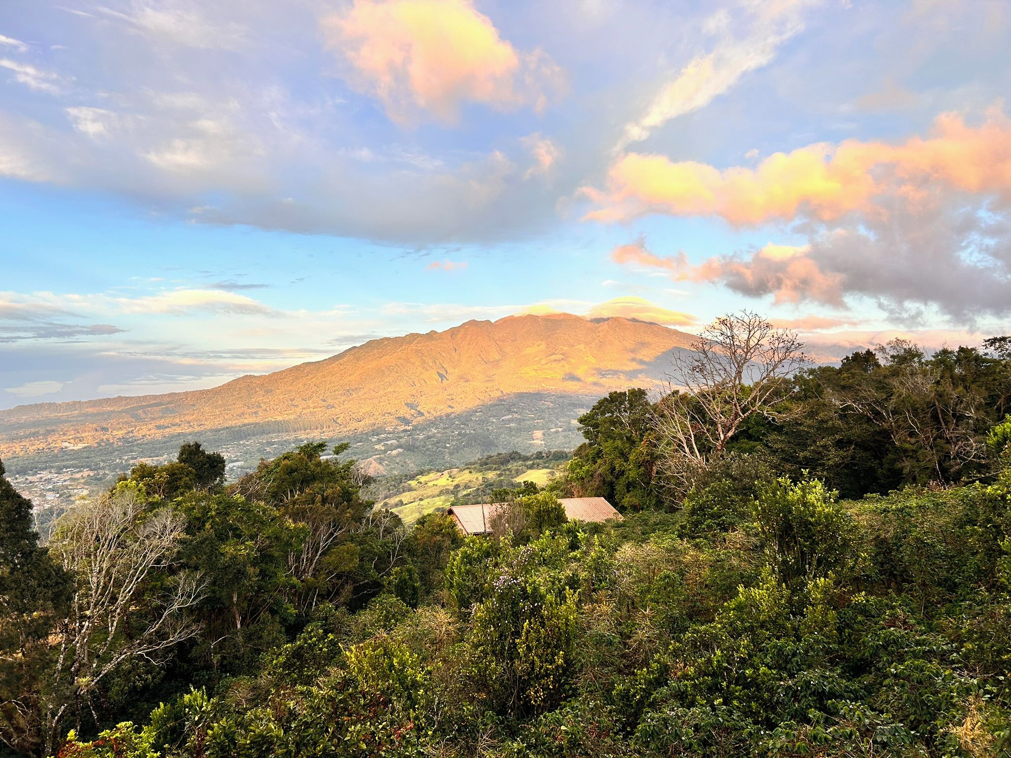 A mountainous landscape with a view of a valley and a small building in the foreground.