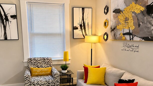 A living room with a sofa, armchair, coffee table, and a lamp. - Adorable 2-bedroom apartment with AC in charming Norwood (Norwood)