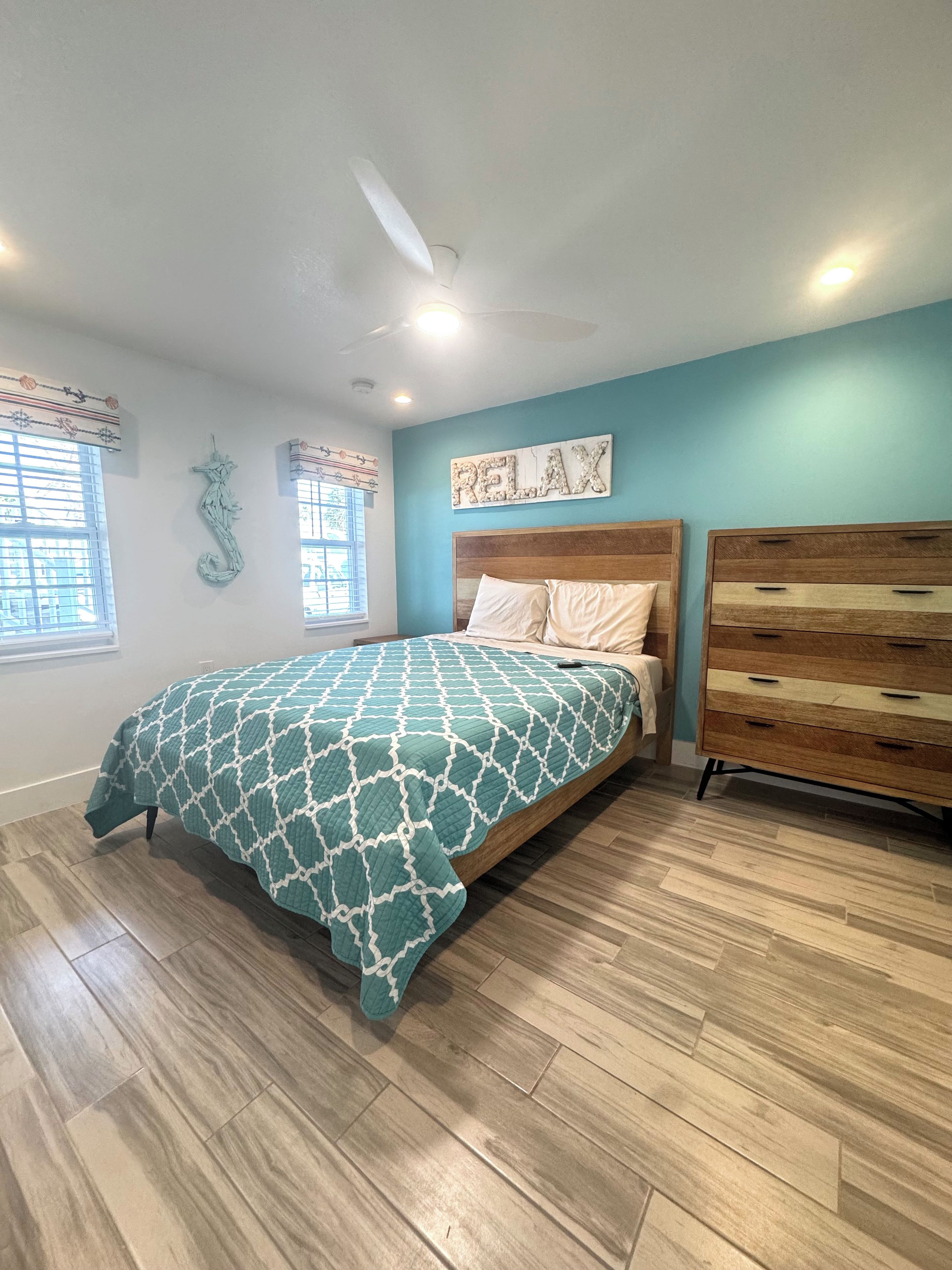 Ein Schlafzimmer mit Bett, Kommode und Wanddekoration.