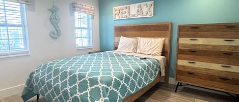 Ein Schlafzimmer mit Bett, Kommode und Wanddekoration.