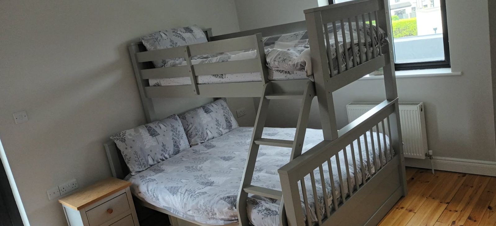 A bunk bed with a lower bunk and a nightstand.