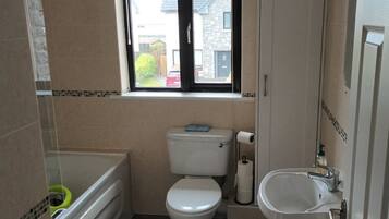 A compact bathroom with a toilet, sink, and bathtub.