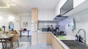 A modern kitchen with a dining area, equipped with a microwave, coffee maker, and a sink. - Luxury 4BR All-ensuite Heated Pool Riverside, Nairobi (Nairobi)