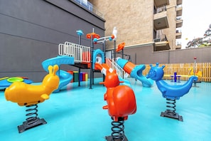 A playground with colorful play equipment including slides and swings. - Luxury 4BR All-ensuite Heated Pool Riverside, Nairobi (Nairobi)