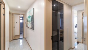 A modern hallway with a wooden door, a glass door leading to a room, and a painting on the wall. - Luxury 4BR All-ensuite Heated Pool Riverside, Nairobi (Nairobi)