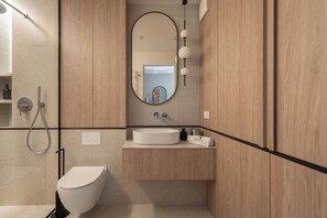 Un baño moderno con inodoro, lavabo y ducha.