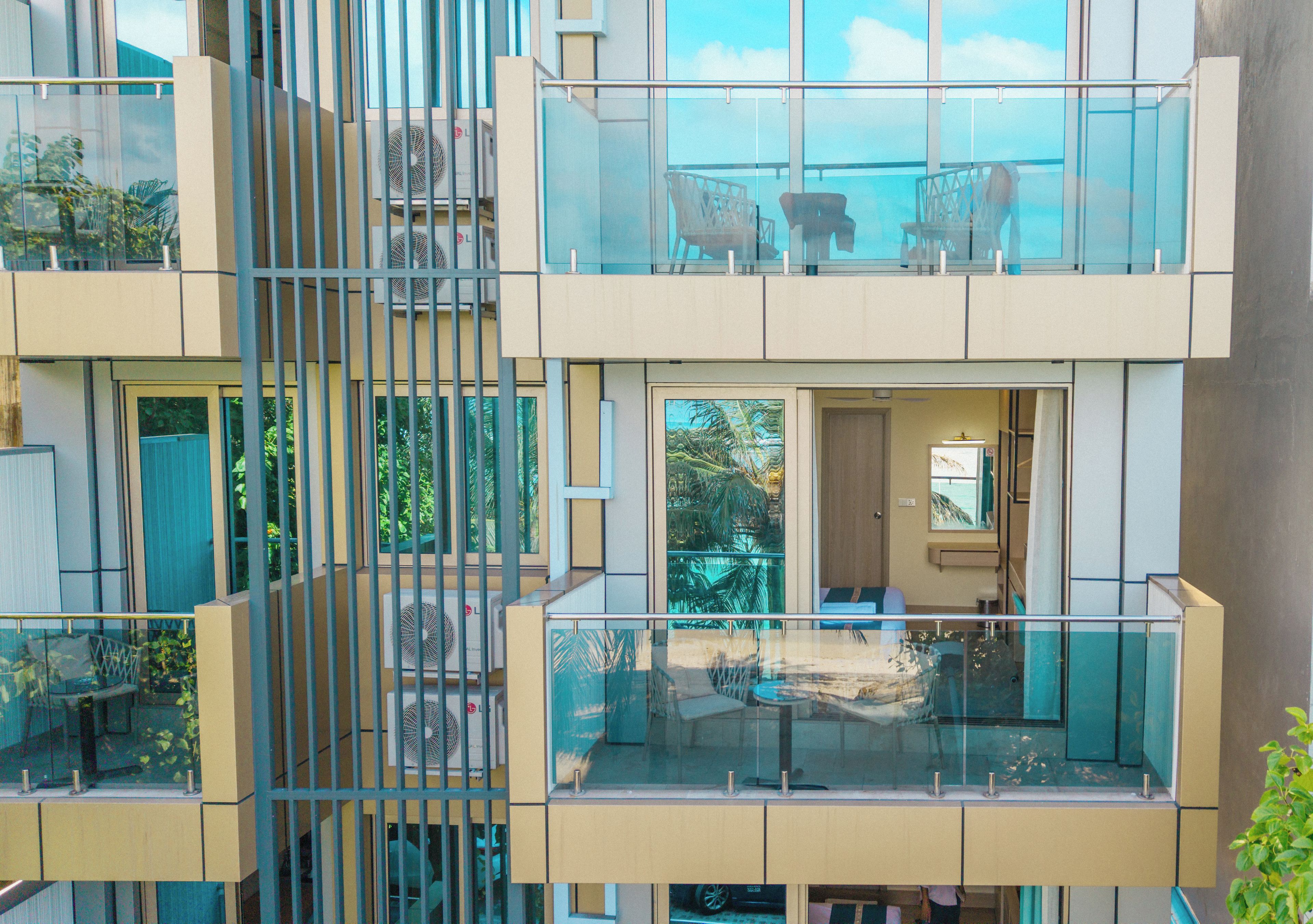 Un edificio moderno de varios pisos con balcones, ventanas amplias y zonas de estar al aire libre.