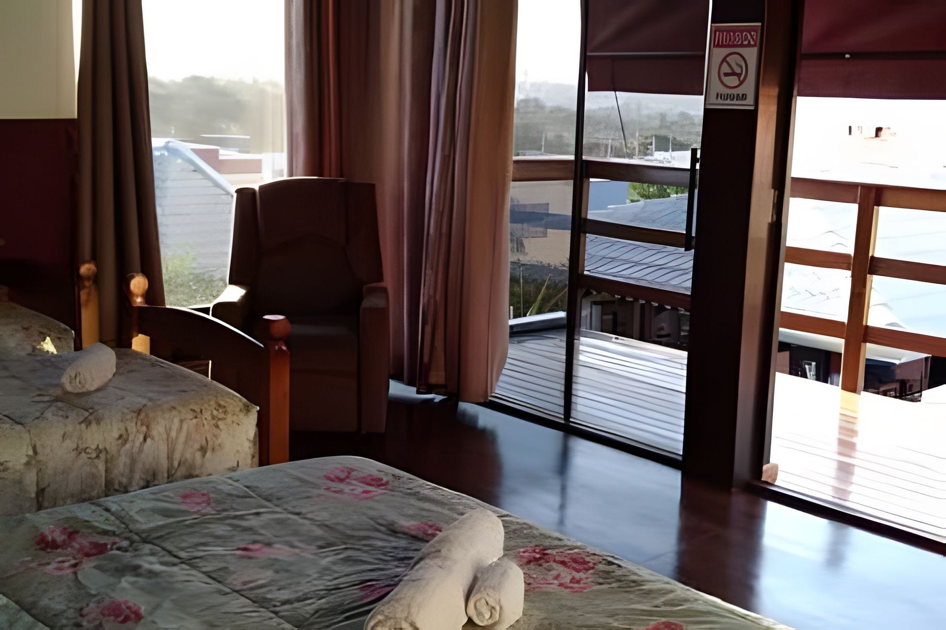 Quarto de hotel com uma cama, uma cadeira e vista para o exterior.