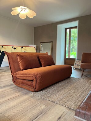 Ein modernes Wohnzimmer mit einer Couch, einem Teppich und einer Deckenleuchte.