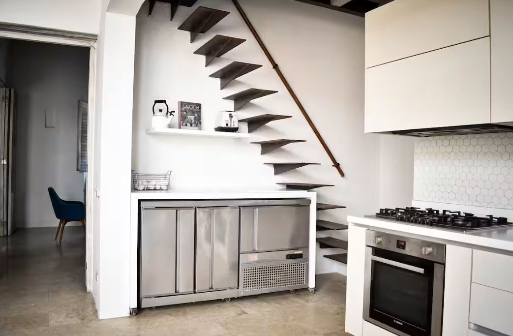 A modern kitchen with a built-in stove, oven, and a white countertop.