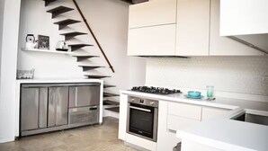Eine moderne Küche mit eingebautem Gasherd, Backofen und Edelstahl-Schränken.