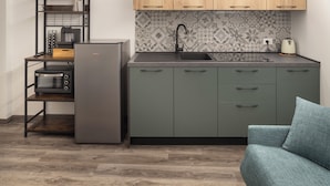 A compact kitchen with a built-in oven, a sink, and wooden cabinets. - Borgo Il Castello, Elsa Apartment (Montichiari)