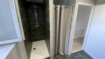 Een moderne badkamer met een douche, toilet en wastafel.
