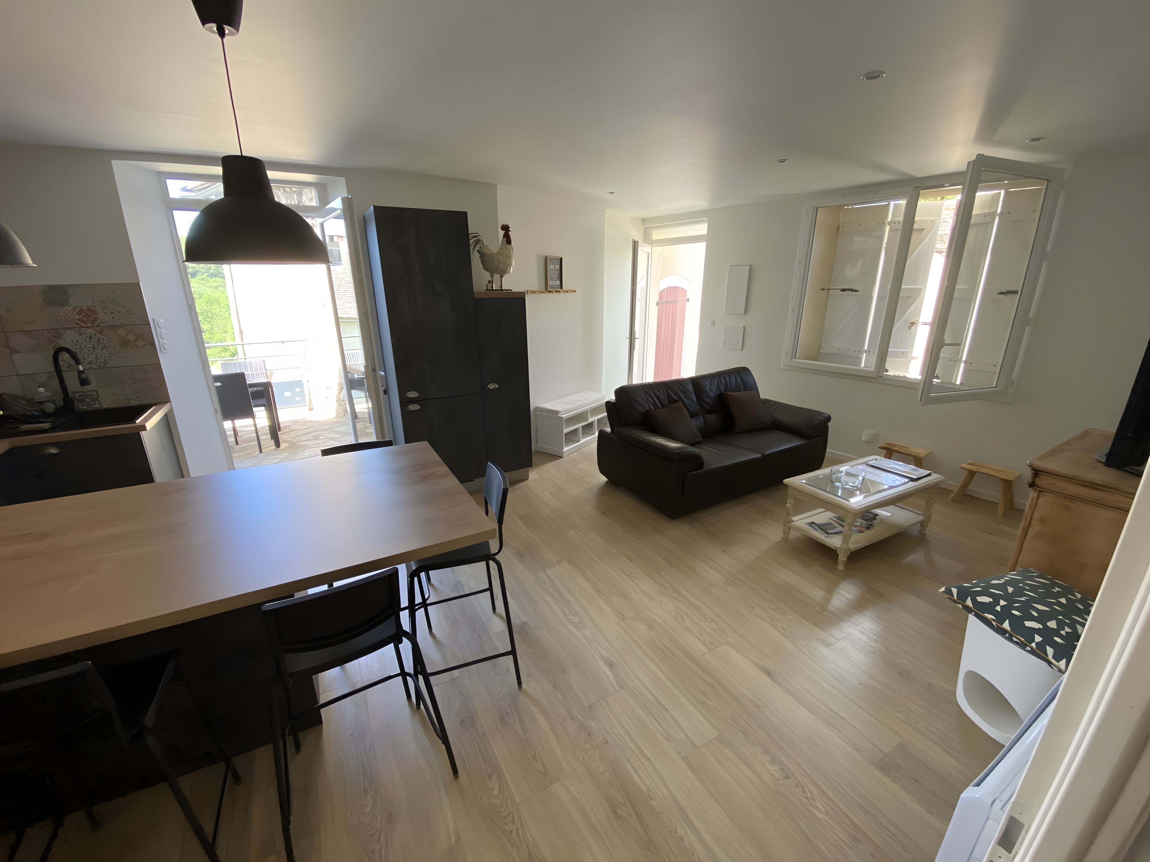 Een moderne woonruimte met een eethoek, een bank, een salontafel en een keuken.