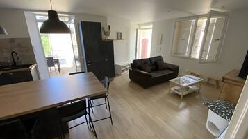 Een moderne woonruimte met een eethoek, een bank, een salontafel en een keuken.