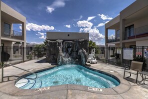 A swimming pool with a waterfall feature, surrounded by a fence, and a lifeguard chair. - Poolside, Dog Friendly Home - 3 King Master En-Suites & Bunk Room (St. George)