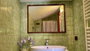 A bathroom with a large oval sink, a mirror, and a shower area. - Cà Fondi  (Lazio)