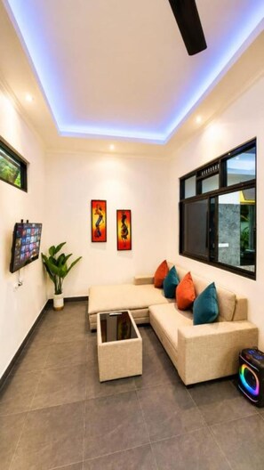 A modern living room with a sectional sofa, a coffee table, and artwork on the walls. - Charming Private Pool Villa in Lovina - Quiet Bali Escape (Buleleng)