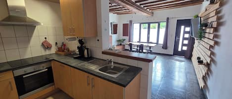 A modern kitchen with wooden cabinets, a stainless steel sink, and a built-in oven.