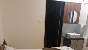 Un letto con una testiera in legno, un materasso bianco e una coperta marrone.