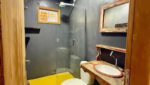 Et badeværelse med toilet, håndvask og bruser.